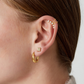 Faux piercing doré à cristaux porté sur cartilage sans perçage