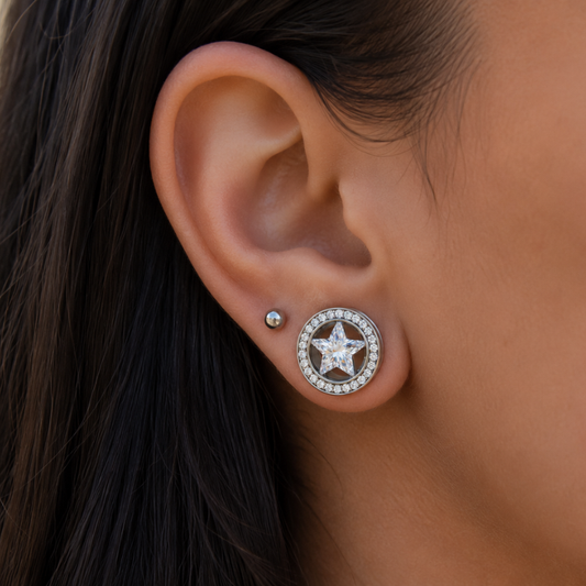Photo portée d'un plug tunnel en acier chirurgical 316L diamètre 14 mm, largeur 6 mm, avec étoile en zircon blanc facetté et contour serti de zircons blancs, vendu à l'unité.
