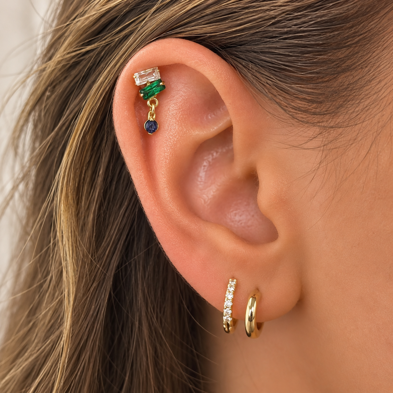 Piercing hélix avec pierres de couleur porté sur jolie oreille